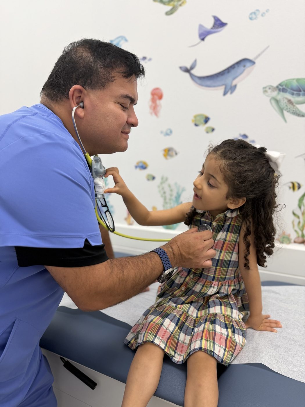Daniel Mego, FNP-C, examining a young pediatric patient
