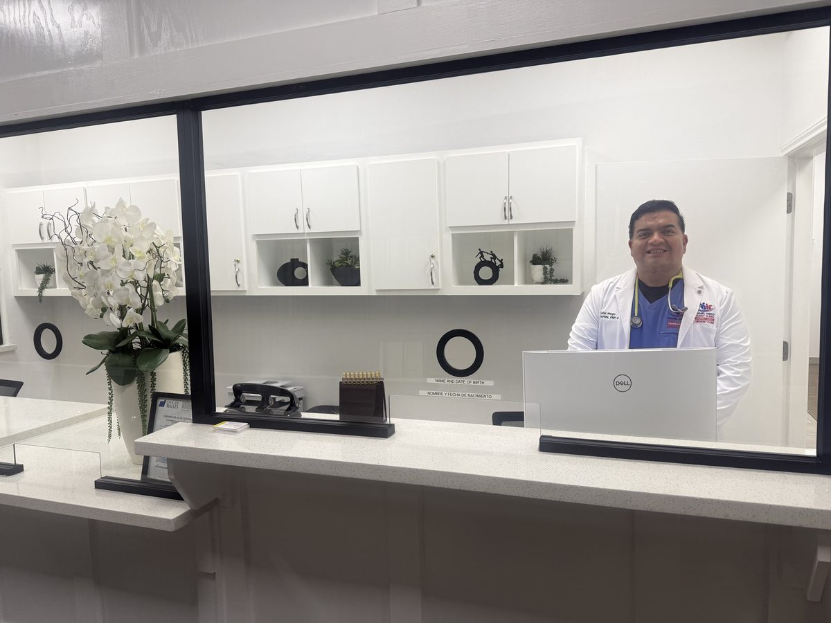 Daniel Mego, FNP-C, standing in a white coat with stethoscope
